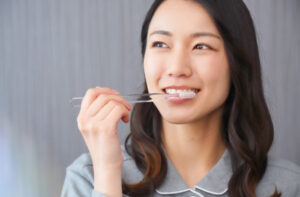 デンタルフロスを使って歯間ケアをする女性